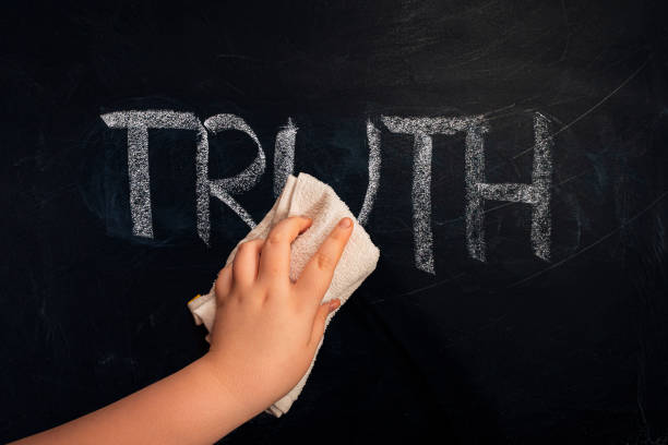 Social issue metaphor - Hand wiping off chalk word truth on chalkboard using rug Social issue metaphor - Hand wiping off chalk word truth on chalkboard using rug sooth stock pictures, royalty-free photos & images