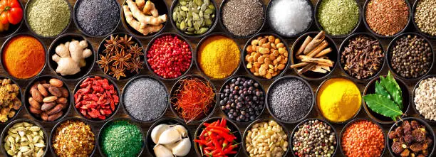 Photo of Colourful background from various herbs and spices for cooking in bowls