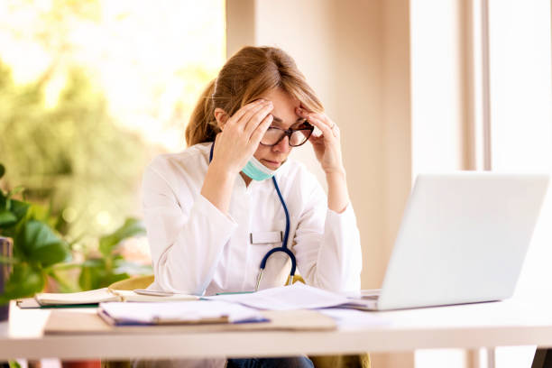 istock Female doctor having a headache while being at doctor's office and working on laptop 1227200330