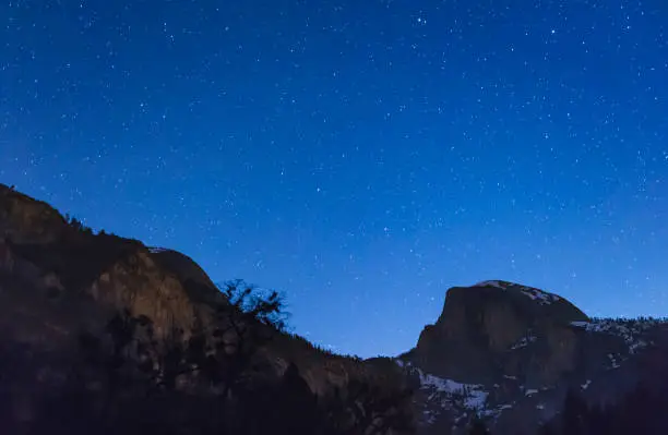 Photo of scene of half dome with sky at night before full moon set in Yosemite National park,California,usa.