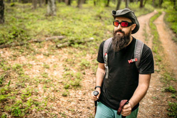 Hiker in the mountain wearing sunglasses, hat and backpack. Happy and active man.