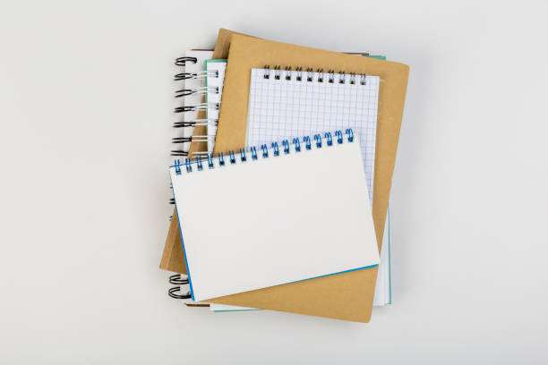 istock a stack of several spiral school notebooks lies on a white table with a pencil, office concept 1227207072