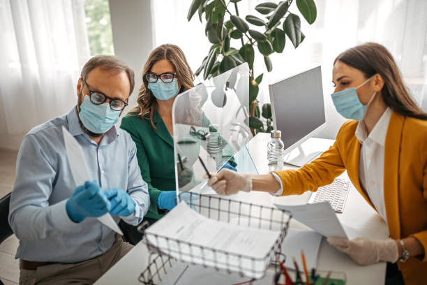 istock Financial advisor explaining contract to customers wearing protective gloves and face mask 1227207337