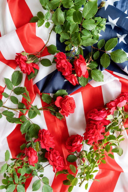 istock Red roses over the USA flag top view flat lay 1227208341