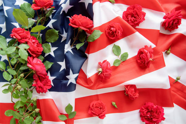 istock Red roses over the USA flag top view flat lay 1227208610