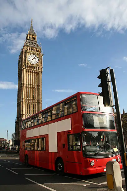 london, the famous double decker bus with advertising space on the side, in front of the the big ben.
