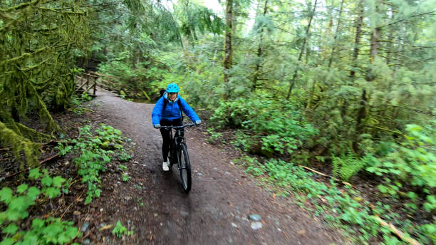 istock Female mountain biker rides e-bike along forested path 1227211340