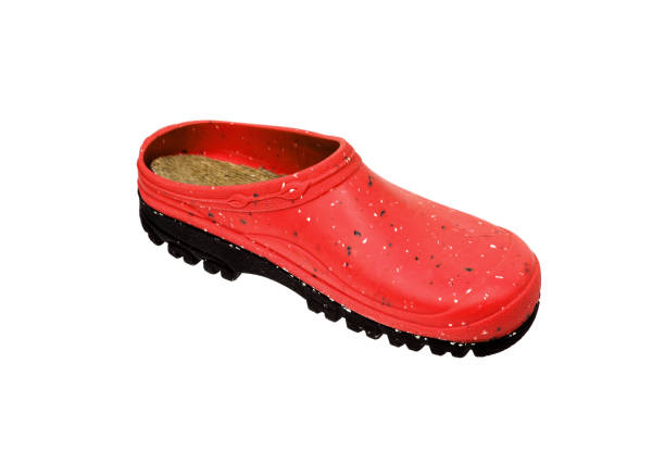 Red boots are resting on a green lawn.