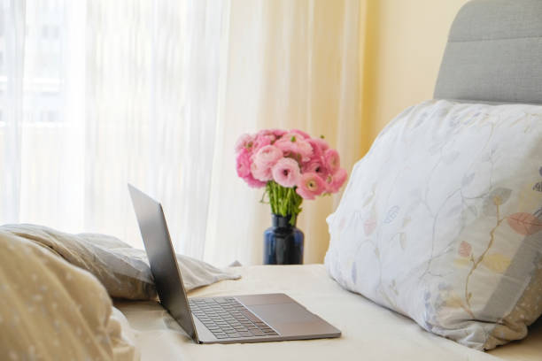 istock Rustic composition with blooming flowers near the unmade empty bed. 1227212751