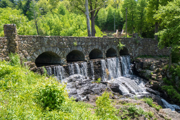 Waterfall under an old stone bridge at the Case Mountain Recreational Area in Manchester, CT stock photo