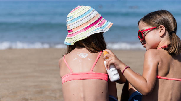 ragazza che mette crema solare sulla pelle della sua amica - child student adolescence cute foto e immagini stock