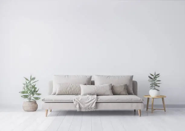 Mock up interior for minimal living room design, beige sofa and green plant in rattan basket. Empty white wall. Stock photo
