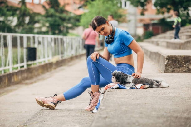 istock Fit young woman sitting on concrete steps with her dog 1227213954