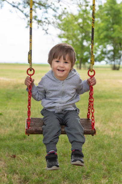 istock Happy beautiful child on swing in nature 1227214698