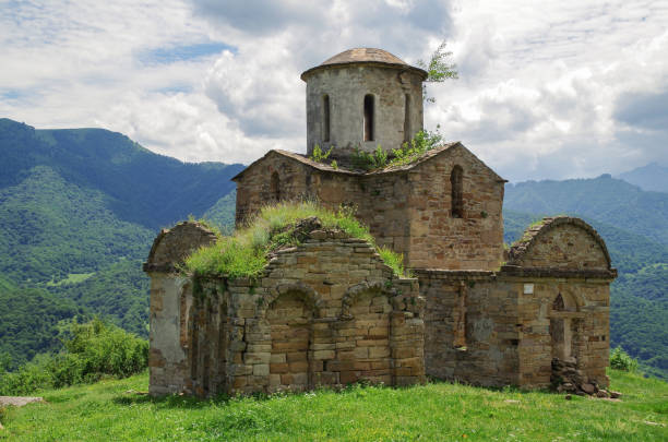 église senty. église chrétienne construite en 965 (alania). il est situé sur l’éperon de chaîne de montagnes sur la rive gauche de la rivière teberda. est la première église datée en russie. - russia river landscape mountain range photos et images de collection