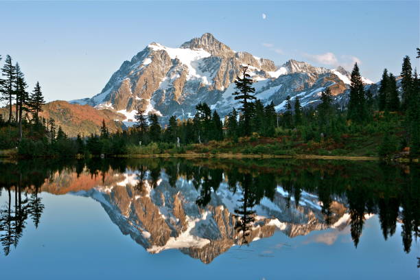 Mt. Shuksan reflects onto Picture Lake in Washington State A late fall day up at Picture Lake in the North Cascades of Washington state shows Mt. Shuksan reflecting perfectly onto the water. cascade range north cascades national park mt baker mt shuksan stock pictures, royalty-free photos & images