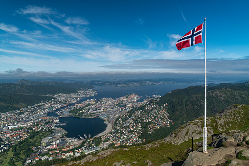 Norwegian flag with a Dramatic aerial view of lake town and fjords in background. Top of Fjords in Southern Norway - European Hiking and travel Concept