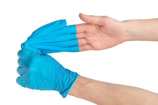 Enfermera quitándola guantes de la mano. De cerca. Aislado en blanco. photo