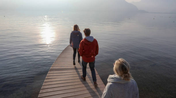 istock Three people walk along curving lake pir, in winter 1227218630