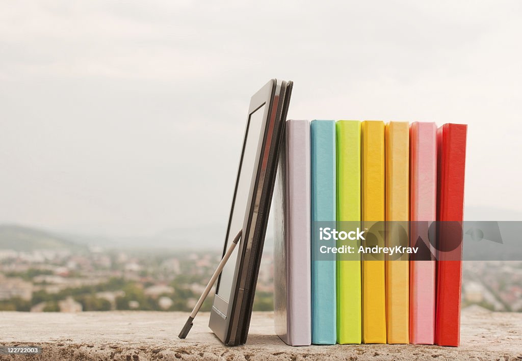Fileira de livros eletrônicos coloridos com leitor de livro - Foto de stock de Amontoamento royalty-free