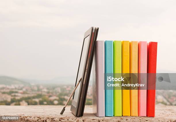 Foto de Fileira De Livros Eletrônicos Coloridos Com Leitor De Livro e mais fotos de stock de Amontoamento