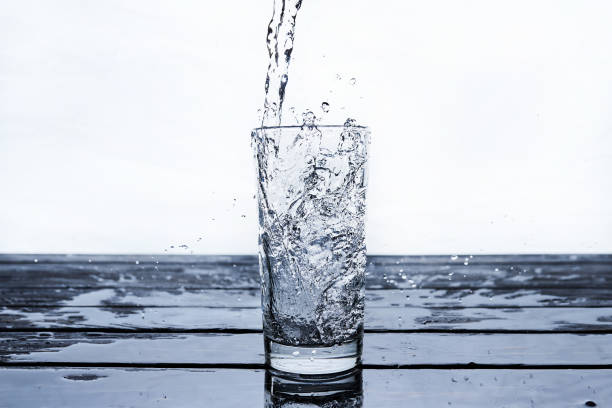 istock water to drink poured into a glass on blue background 1227221650