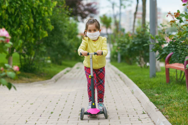 istock Young girl is using scooter with a mask 1227222466