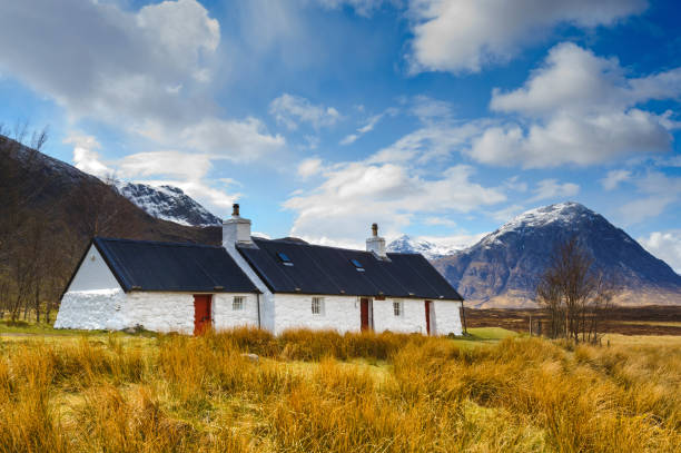Black Rock Cottage, Glencoe, Scotland, UK Glenncoe, Scotland, UK - 18th April 2012: Wide angle view of the iconic Black Rock Cottage in Glencoe. This area is known for having waterfalls and trails that climb peaks such as Buachaille Etive Mor that can be seen in the background. buachaille etive mor photos stock pictures, royalty-free photos & images