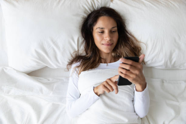 istock Top view beautiful woman using phone, relaxing in bed 1227225874