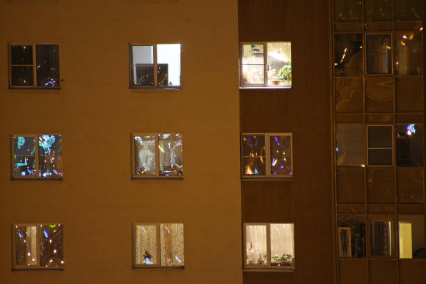 finestre luminose di appartamenti di notte - apartment building exterior urban scene window foto e immagini stock