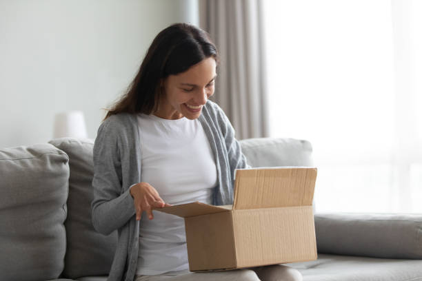 istock Happy beautiful woman received parcel, unpacking cardboard box 1227225948