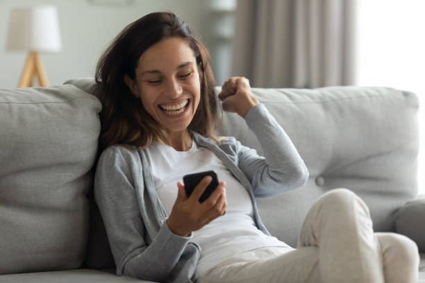 istock Excited woman using phone, celebrating online win, good message 1227225979