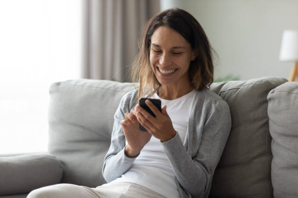 istock Happy laughing woman using phone, having fun at home 1227226009