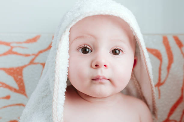 istock baby boy getting dried with towel in bathroom. 1227226078