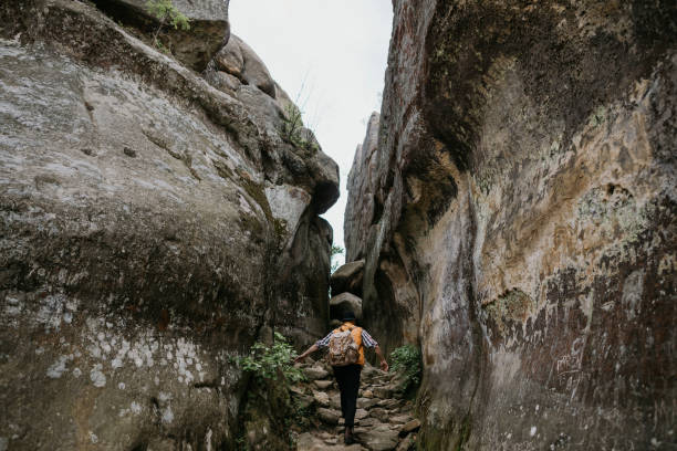 istock man hiker with a backpack climbs into the mountains by a rocky gorge. Travel concept 1227229507
