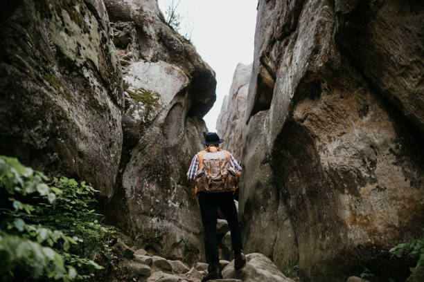 istock A lone man hiker stands in the mountains between two high cliffs. Extreme summer vacation 1227229548