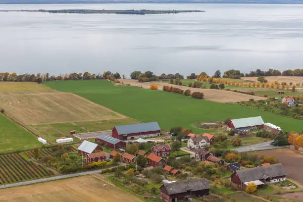 View of Lake Vattern with a picturesque little Swedish village and the plowed field on the coast photographed from the fortress Brahehus in Granna, Jonkoping, Sweden.
