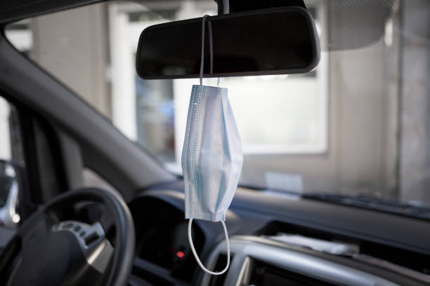 istock Face mask hanging on the rear-view mirror 1227230592