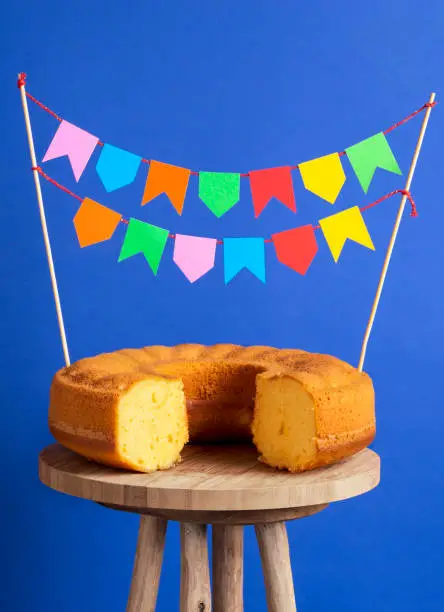 Party flags stuck in a cornmeal cake. Sweet food ready for the famous brazilian celebration called Festa Junina