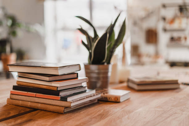 pila di libri sul tavolo nella stanza. - bibliophile foto e immagini stock