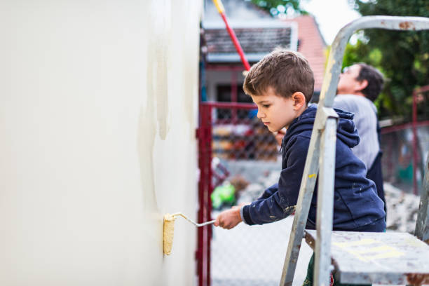 istock Boy helping his grandfather painting the wall 1227237580