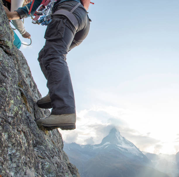 istock Young woman climbs steep rock wall on belay 1227237924