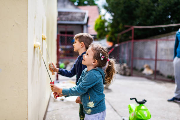 Children helping painting the wall