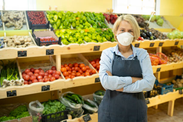 ritratto di giovane donna d'affari proprietaria di un negozio di alimentari con maschera facciale - end product foto e immagini stock