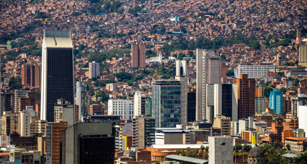 Very populated city made of clay bricks Aerial view of Medellin City downtown showing a lot of buildings including the most emblematic one, The Coltejer Building population explosion photos stock pictures, royalty-free photos & images