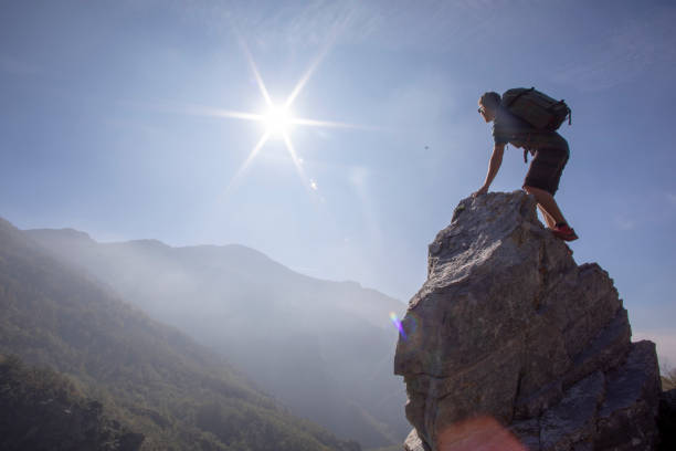 istock Young man hiker climbs pinnacle above distant mountains 1227239211