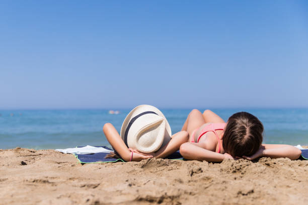 Sunbathing on the beach Girls lying on the beach, enjoying the sun girls laying on beach stock pictures, royalty-free photos & images