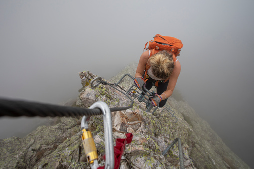 She is climbing up a steep ridge line