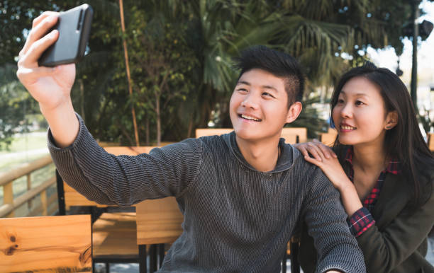 istock Asian couple taking a selfie with mobile phone. 1227243629