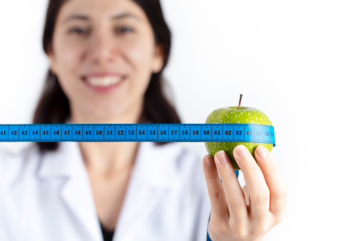 green apple and tape measure. healthy eating and diet concept. isolated in white background.